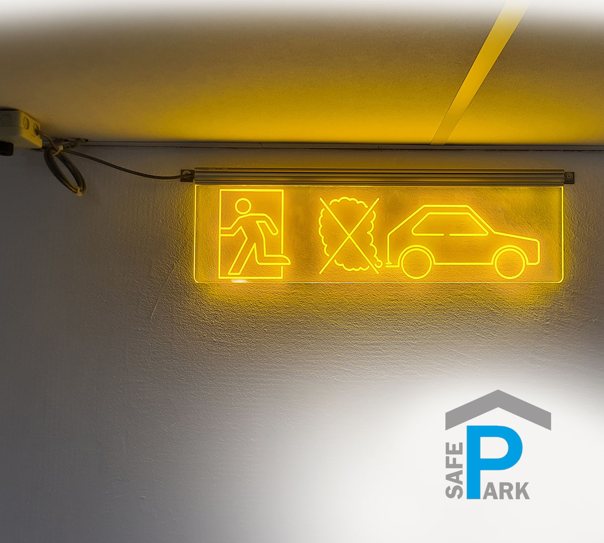Warning sign for CO gas warning system_in parking garages_Bieler+Lang_SafePark_illuminated_transparent_underground_parking_pictogram_yellow_flashing_in_front_of_garage_wall